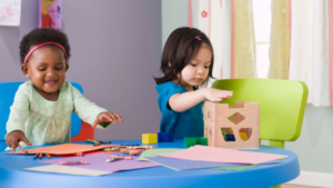 Children playing with paper and blocks at daycare