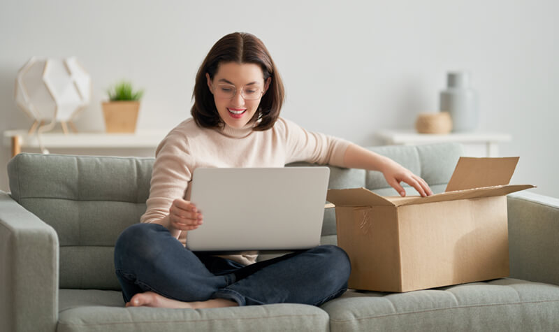 smiling woman holding a cardboard box