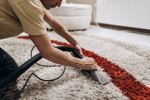 man doing deep cleaning and dirt removing on carpet