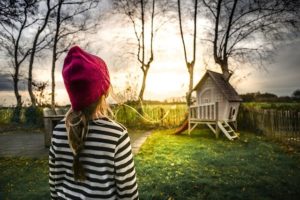 little girl in backyard with playscape