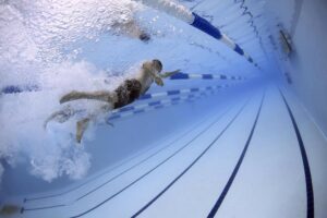 student swimming in a lane, representing competition